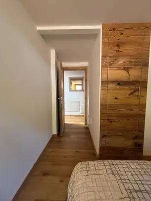 a room with a bed and a large wooden closet at Pragma Apartments - Wood Lodge Predazzo in Predazzo