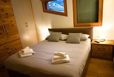 a bedroom with a bed with towels on it at Pragma Apartments - Wood Lodge Predazzo in Predazzo