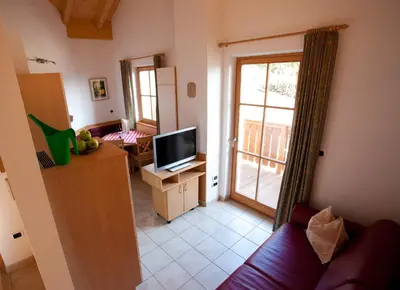 a living room with a couch and a television at Gasserhof Aicha in Naz-Sciaves