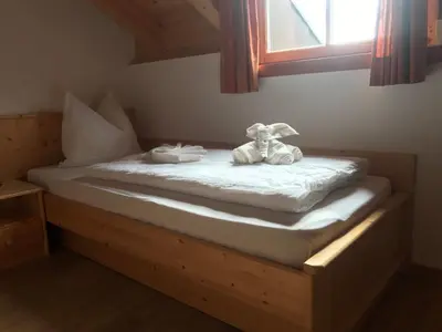 a stuffed animal sitting on a bed in a room at Gasserhof Aicha in Naz-Sciaves