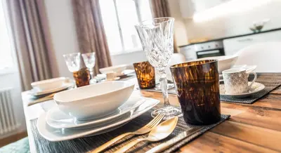 a wooden table with plates and silverware on it at Park Residence Apartments in Bolzano
