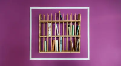 a book shelf filled with books on a purple wall at Park Residence Apartments in Bolzano