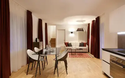 a kitchen and living room with a table and chairs at Park Residence Apartments in Bolzano