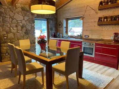 a kitchen with a dining room table and chairs at Dolomite Nest in Cencenighe