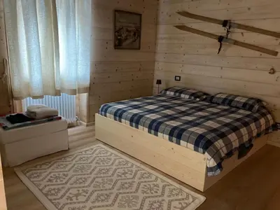 a bedroom with a bed in a wooden wall at Dolomite Nest in Cencenighe