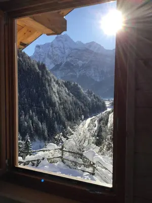 a view of a snowy mountain from a window at Dolomite Nest in Cencenighe