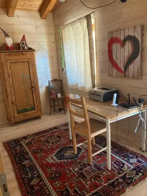 a dining room with a wooden table and acomputer on the wall at Dolomite Nest in Cencenighe