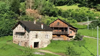 an old stone house on a grassy hill at Dolomite Nest in Cencenighe