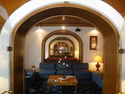 a living room with a blue couch and an archway at Hotel Majoni in Cortina dʼAmpezzo