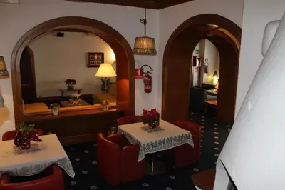 a restaurant with two tables and a mirror at Hotel Majoni in Cortina dʼAmpezzo
