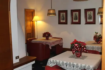 a dining room with two tables with red chairs at Hotel Majoni in Cortina dʼAmpezzo