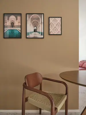 a chair and a table with three pictures on the wall at LIMIX Stays in Appiano sulla Strada del Vino