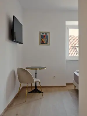a room with a table and a chair and a television at LIMIX Stays in Appiano sulla Strada del Vino