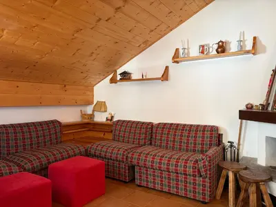 a living room with two couches and a fireplace at Mansarda Veronza in Castello di Fiemme