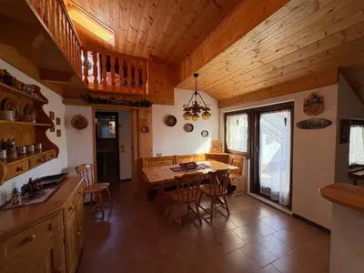 a kitchen and dining room with a wooden ceiling at Mansarda Veronza in Castello di Fiemme
