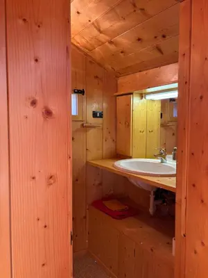 a bathroom with a sink in a wooden cabin at Mansarda Veronza in Castello di Fiemme