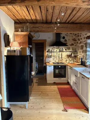a kitchen with white cabinets and a black refrigerator at Il Tabià