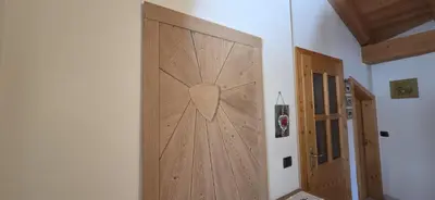 a wooden door in the corner of a room at Casa dal Cialie in Vigo di Fassa