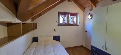 a small bedroom with a bed and a window at Casa dal Cialie in Vigo di Fassa
