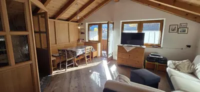 a living room with a couch and a television at Casa dal Cialie in Vigo di Fassa