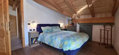 a bedroom with a large bed and a fireplace at Casa dal Cialie in Vigo di Fassa