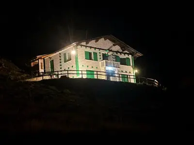 a house on top of a hill at night at Rifugio TEA Dolomiti in Falcade