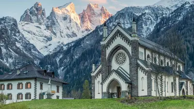 a large building in front of a mountain at Rifugio TEA Dolomiti in Falcade