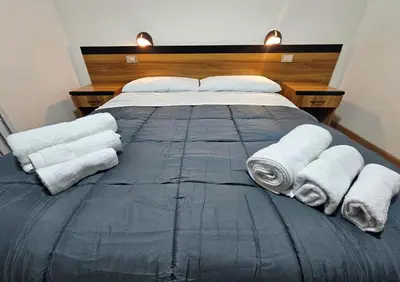 a bedroom with a large bed with towels on it at Rifugio TEA Dolomiti in Falcade