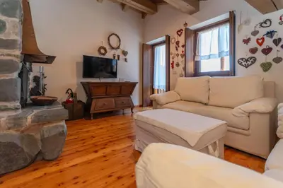 a living room with a couch and a fireplace at Dreamful Cottage in Selva di Cadore