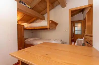 a room with two bunk beds and a table at Dreamful Cottage in Selva di Cadore
