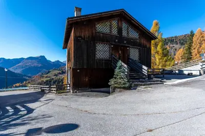 a small wooden building with a christmas tree in front at Dreamful Cottage in Selva di Cadore