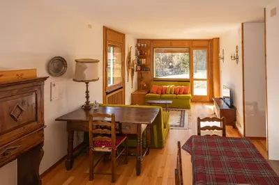 a living room with a table and a couch at Cortina - Chalet Pocol 22 in Pocol
