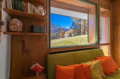 a green couch in a room with a window at Cortina - Chalet Pocol 22 in Pocol