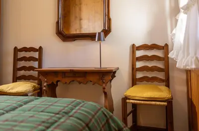 a bedroom with a table and two chairs and a bed at Cortina - Chalet Pocol 22 in Pocol