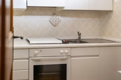 a white kitchen with a sink and a stove at Cortina - Chalet Pocol 22 in Pocol