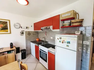 a kitchen with red and white cabinets and a refrigerator at Apartment Val Fiemme by Interhome in Cavalese