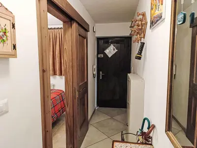 a hallway with a black door and a refrigerator at Apartment Val Fiemme by Interhome in Cavalese