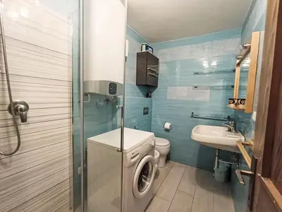 a bathroom with a washing machine and a sink at Apartment Val Fiemme by Interhome in Cavalese