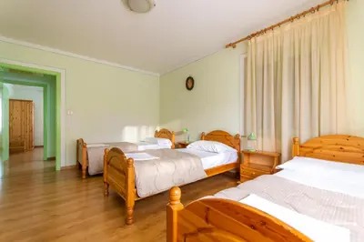 a bedroom with three beds and wooden furniture at Casa Iris in Falcade