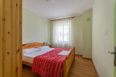 a bedroom with a bed with a red blanket at Casa Iris in Falcade