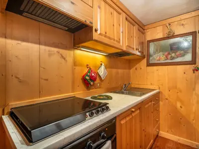 a kitchen with a sink and a stove at Angiolina Charming Apartment R&R in Cortina dʼAmpezzo