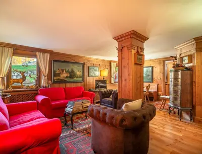 a living room with red furniture and wooden walls at Angiolina Charming Apartment R&R in Cortina dʼAmpezzo