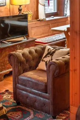 a brown couch with a pillow on it in a living room at Angiolina Charming Apartment R&R in Cortina dʼAmpezzo