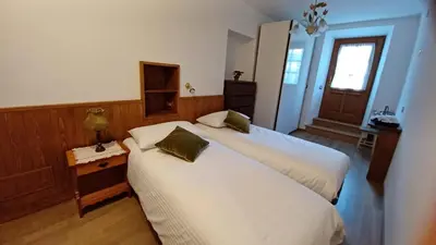 a bedroom with two beds and a table and a window at Bella Cortina - comodo al centro e impianti, con garage in Cortina dʼAmpezzo