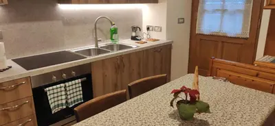 a kitchen with a table and a sink at Bella Cortina - comodo al centro e impianti, con garage in Cortina dʼAmpezzo