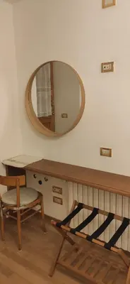 a mirror on a wall with a desk and a chair at Bella Cortina - comodo al centro e impianti, con garage in Cortina dʼAmpezzo
