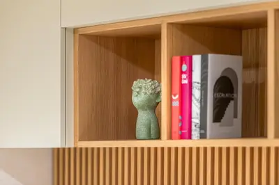 a green vase sitting on a shelf with books at Cademai Alpenglow Chalet with Sauna R&R in Cortina dʼAmpezzo