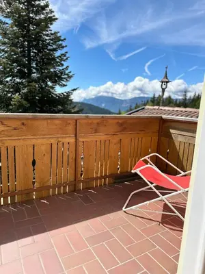 a red chair sitting on a patio with a fence at Grunen Baum - Vöran in Verano