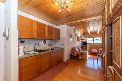 a kitchen with wooden cabinets and a wooden ceiling at Casa Paola in Rocca Pietore