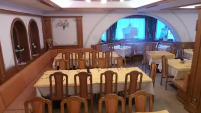 a bedroom with a white bed and a chair at Hotel Pordoi - Fam Furgler in Arabba